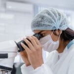 Γυναίκα παρατηρεί δείγμα με μικροσκόπιο, ενδεικτική εικόνα για την ανακάλυψη νέου βραδύπορου