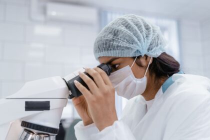 Γυναίκα παρατηρεί δείγμα με μικροσκόπιο, ενδεικτική εικόνα για την ανακάλυψη νέου βραδύπορου
